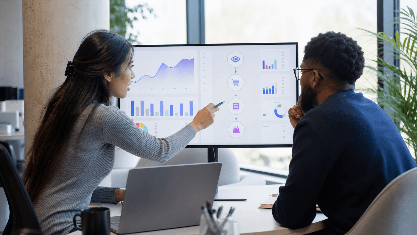 Hero image of a performance marketer and developer reviewing a conversion-event funnel on an analytics monitor.